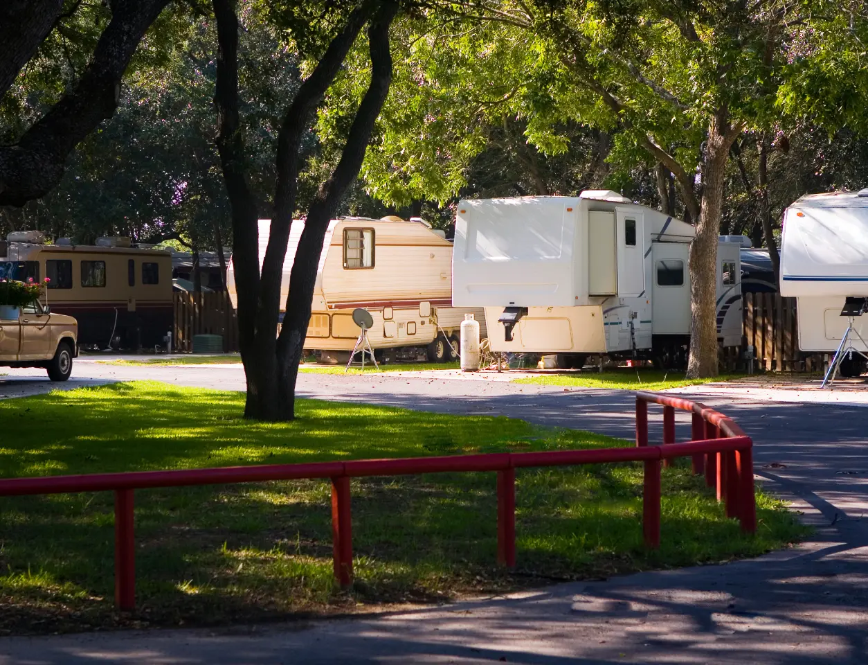 RV park with trees and red fence.